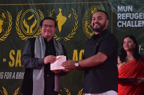 A delegate honoured on stage in front of the MUN Refugee Challenge backdrop